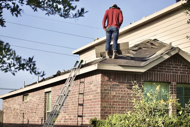 Professional roofer working on a residential roof in Marshfield Center